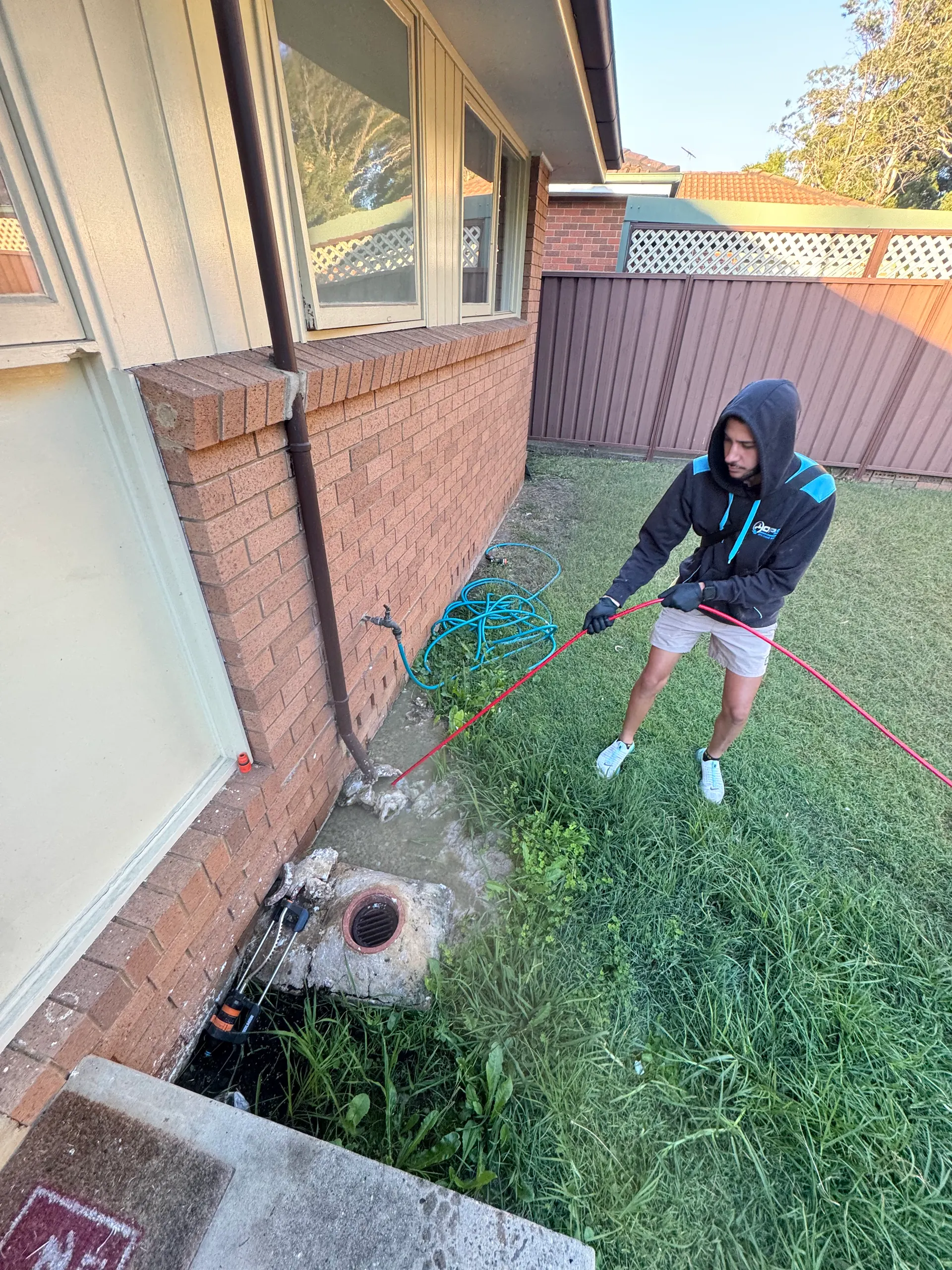 Jere from OPS clearing a blocked sewer drain in Concord with red drain cables